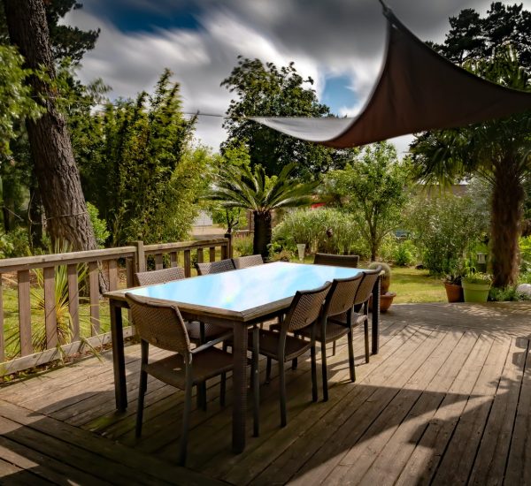 brown wooden table with chairs and umbrella