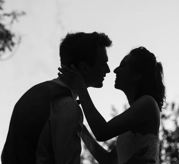 silhouette grayscale photo of man and woman attempting to kiss